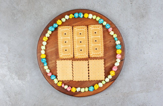 饼干在大理石背景的木板上 饼干被糖果围成一个圈高质量的照片可口糖果美味