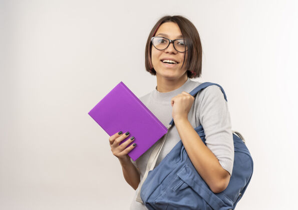 学生快乐的年轻女学生戴着眼镜 背着书包 把书孤立在白色的地板上背戴高兴