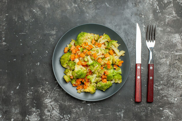 健康餐健康餐 黑盘子和灰桌子上放花椰菜和胡萝卜菜肴厨具炊具