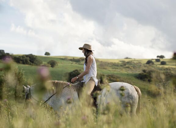 乡村女农民骑马侧视图老人农场生活骑马