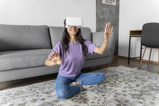 享受笑脸女人在家里用虚拟现实耳机家庭虚拟现实眼镜休闲