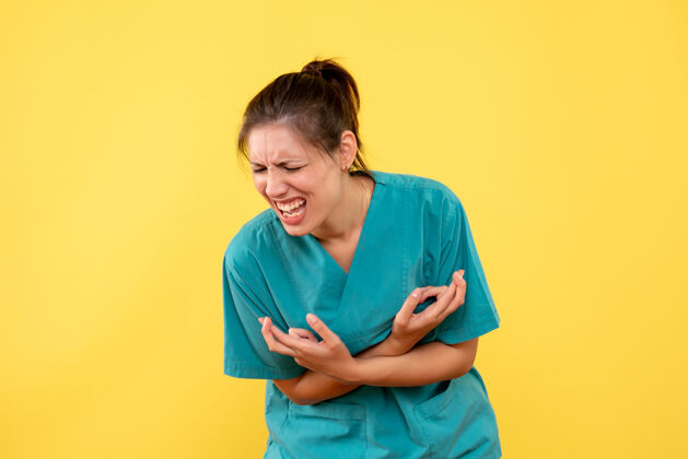医疗正面图黄色背景上穿着医用衬衫的女医生疼痛难忍人病毒健康