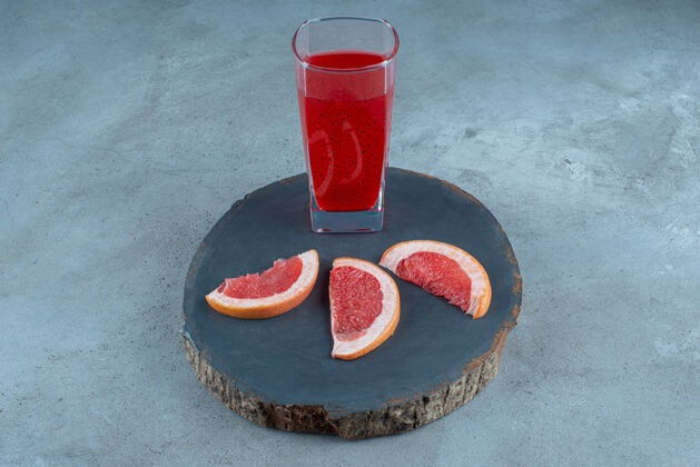 玻璃杯一杯红果汁加葡萄柚片杯子水果木头