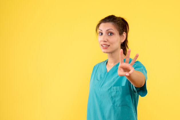 人前视图黄色背景上穿着医用衬衫的女医生医生女医生护士