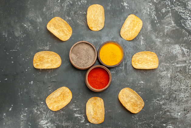 封闭自制薯片排成一圈 蛋黄酱番茄酱香料放在灰色的桌子上石头坚果鹅卵石