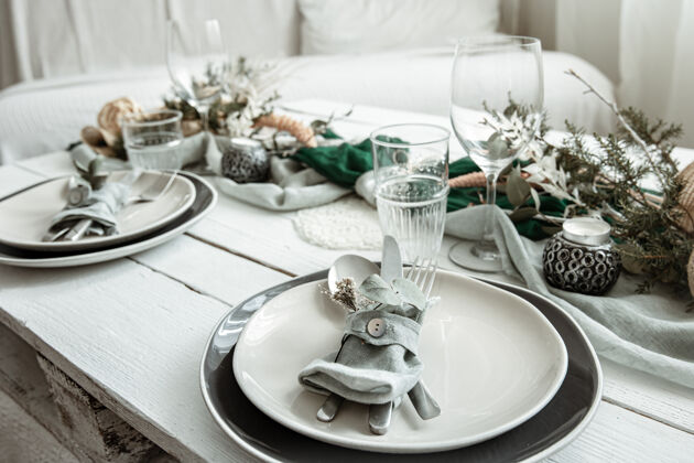 蜡烛在家里的节日餐桌设置与斯堪的纳维亚装饰细节特写房子设置玻璃