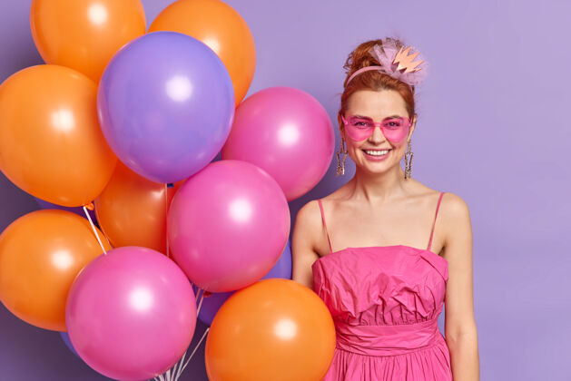 心情积极快乐的女人在情人节派对上带着五彩缤纷的气球穿着复古风格的衣服和配饰摆姿势氦女性庆典