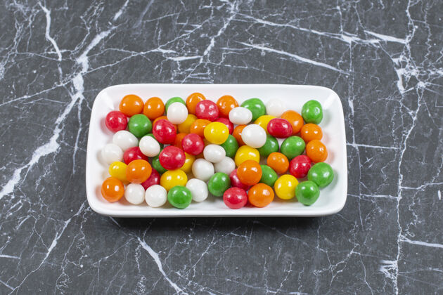 邦邦美味的彩色糖果放在白色盘子里糖果糖果甜点