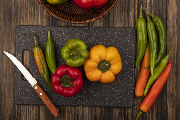 辣黑色菜板上营养辣椒的俯视图 菜刀将辣椒隔离在木质表面蔬菜营养食物