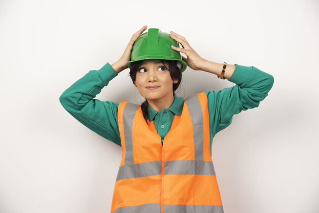 工作一位手持白色背景头盔的女工程师高质量照片人女人工头