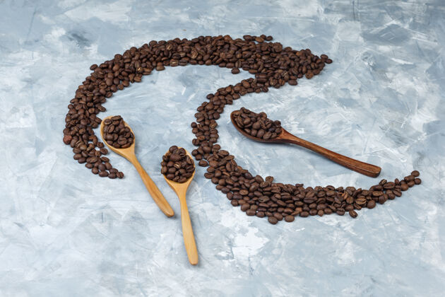 高一些咖啡豆放在灰色灰泥背景的木勺里 高角度观看美食阿拉比卡咖啡馆