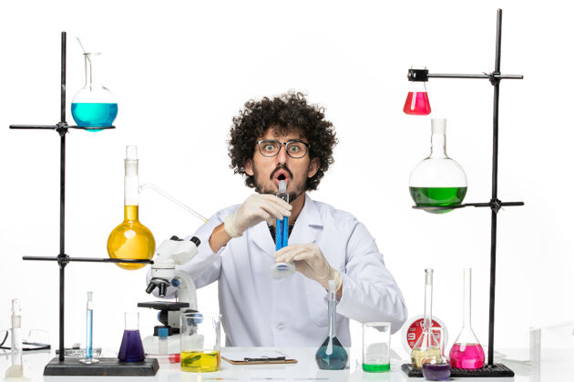 科学正面图穿着医疗服的男性化学家拿着蓝色溶液在一个空白处化学医生职业