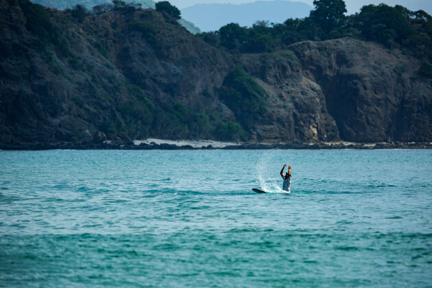 热带在蓝色波浪上冲浪骑巴厘岛冲浪