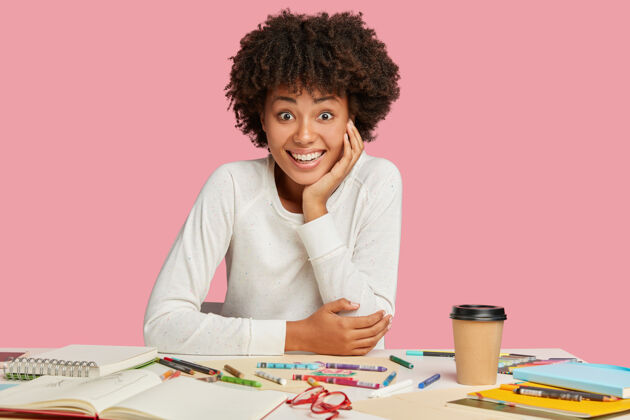 工作快乐的黑人设计师为素描着想 笑得牙牙学语桌子高兴办公桌