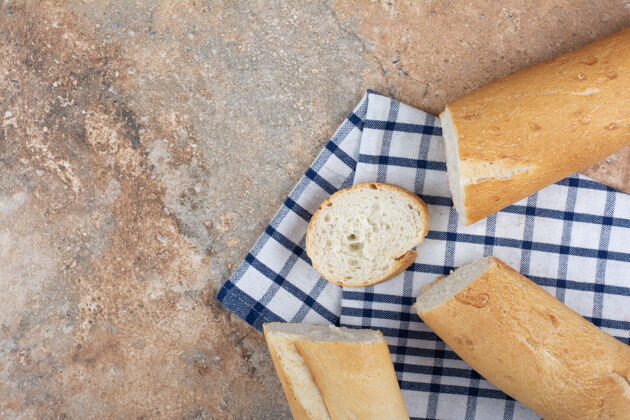 面包新鲜的法式面包片在条纹桌布上食品新鲜面包