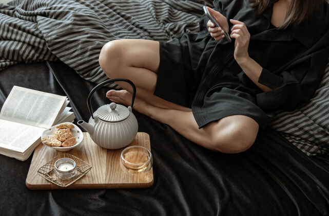 房子一个女人正在用茶和饼干吃早餐 休息日躺在床上室内红茶早餐
