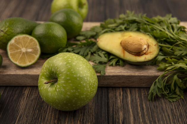 厨房顶视图健康的绿色苹果与酸橙鳄梨和欧芹隔离在一个木制的厨房板上的木墙农业顶部食品