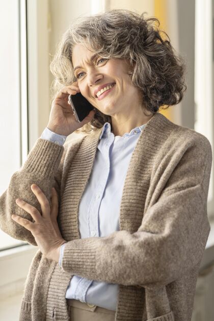 肖像在手机上说话的肖像女人现代女人电话交谈设备