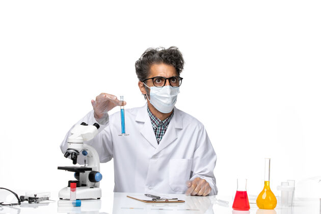 外套正面图中年科学家穿着特制的衣服坐着拿着装有溶液的烧瓶男性实验实验室