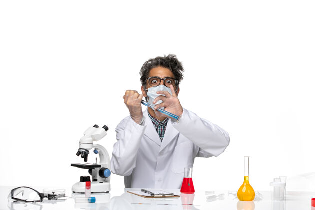人正面图身着白色医疗服的中年科学家用蓝色溶液注射剂注射正面人