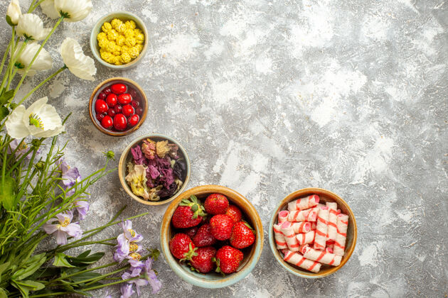 多汁顶视图新鲜的红色草莓和糖果在白色表面新鲜的糖果浆果可食用的水果有机甜点