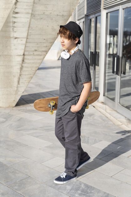 耳机十几岁的男孩玩滑板溜冰男孩滑板