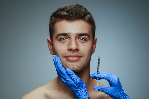 嘴唇隔离在灰色背景上的年轻人的特写肖像填充手术程序白种人英俊灰色