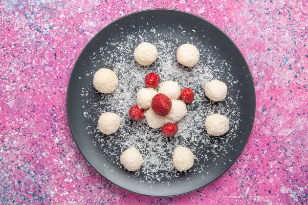 美味粉红色表面上美味的椰子糖甜球俯视图新鲜健康食物