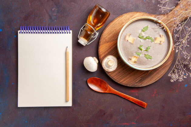 勺子顶视图美味的蘑菇汤在盘子里一个深色的背景上汤菜一餐晚餐的食物蘑菇勺子叉子