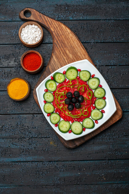 蔬菜俯视图在一个黑暗的乡村桌子上盘子里有橄榄切片黄瓜饮食沙拉蔬菜维生素健康盘子午餐托盘