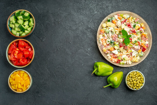 饭一碗蔬菜沙拉的俯视图 深绿色的桌子上有几碗蔬菜和甜椒午餐蔬菜餐厅