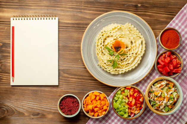 生的顶视图生面团与蔬菜和调味品在棕色桌面团食物面团餐餐厅美食晚餐