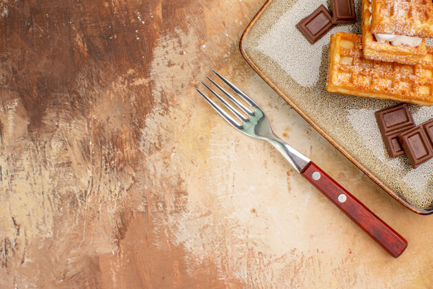 工具俯瞰美味的华夫饼与巧克力条棕色背景甜点饼干木头