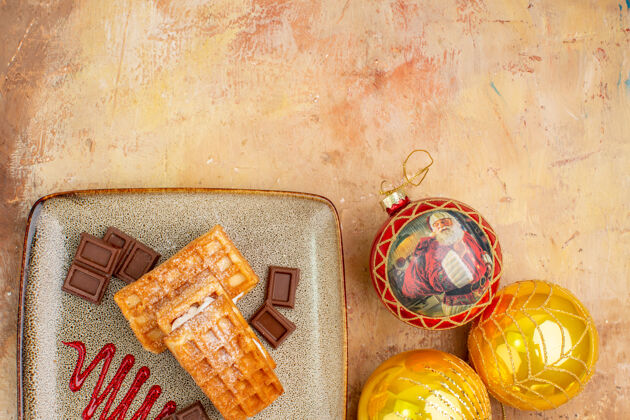 食物俯瞰美味的华夫饼与巧克力和新年树玩具的背景光奶油巧克力背景
