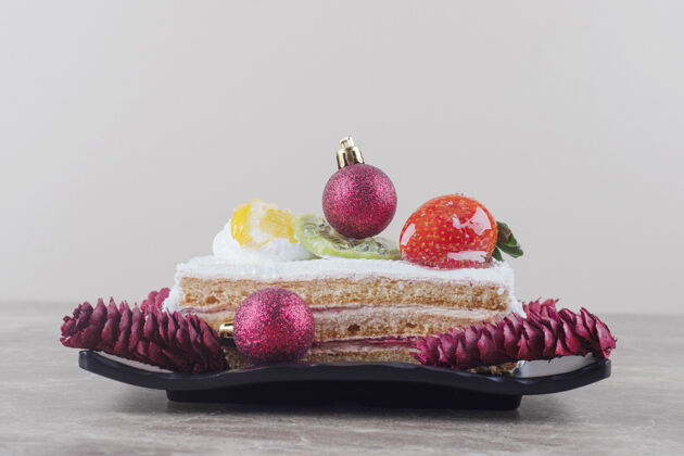 节日蛋糕片放在盘子上 用大理石装饰节日的装饰品美味烘焙拼盘