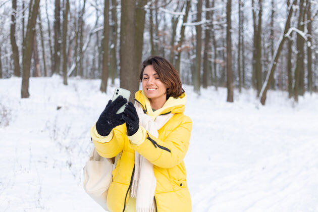脸年轻美丽快乐开朗的女子在冬季森林视频博客 自拍照片假期自然互联网