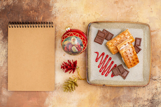 甜点俯瞰美味的华夫饼与巧克力条棕色背景圣诞节包巧克力