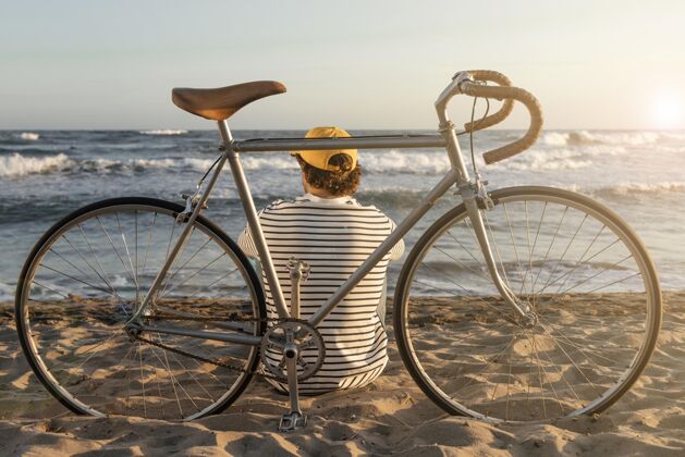 沙滩坐在海边的全明星男人年轻自行车