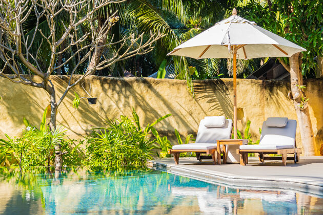 休息室在度假酒店的室外游泳池周围放上雨伞和椅子 供度假休闲之用甲板豪华花园