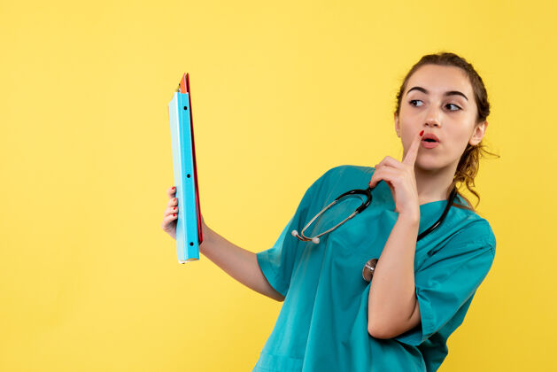 女性正面图女医生穿着医用衬衫拿着不同的纸条 彩色病毒健康情绪covid-19大流行黄色注释不同