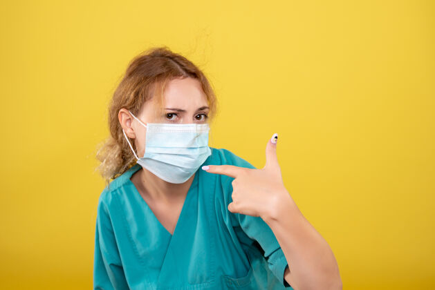 女人正面图女医生穿着医用衬衫和无菌口罩 彩色covid-19病毒健康情绪大流行医生医学黄色