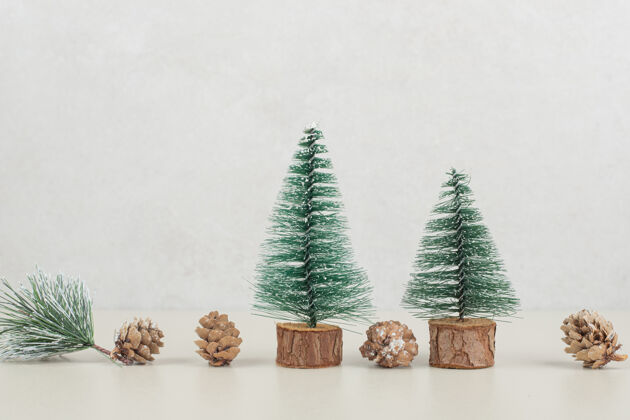 圣诞节米色表面的迷你圣诞树和松果节日雪松节日