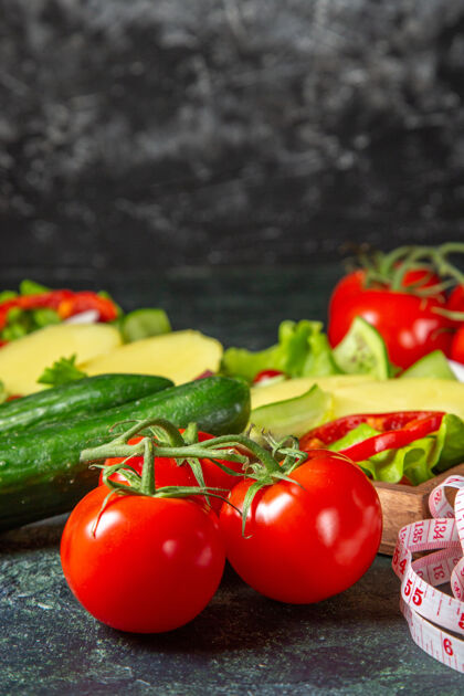 蔬菜切碎的蔬菜垂直视图新鲜的西红柿与茎米和黄瓜在一个木托盘上的混合颜色的表面胡椒黄瓜沙拉