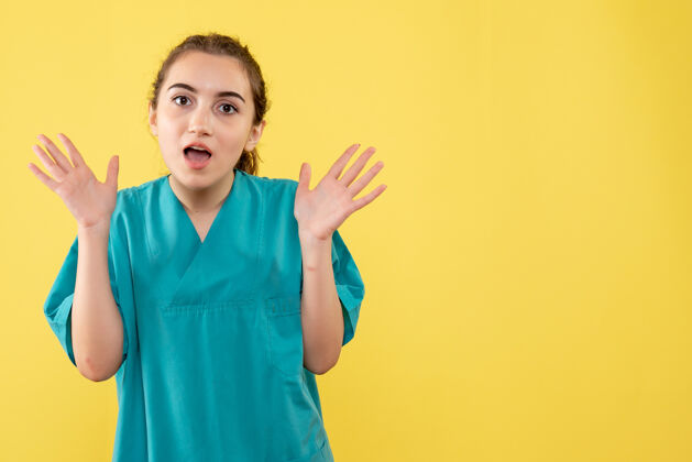 特纳黄墙上年轻女医生身着医疗服的正面图年轻女医生刮刀正面