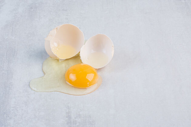 蛋壳一个鸡蛋在大理石桌上破开了有机鸡蛋蛋黄