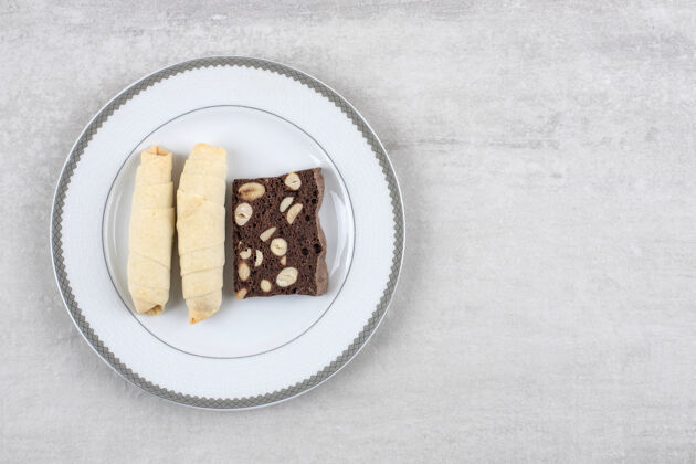 卡路里自制巧克力布朗尼和卷饼干放在盘子里 放在大理石桌上饼干烘焙自制