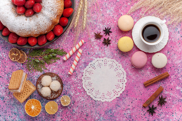 杏仁饼俯瞰美味的草莓派 配上法国马卡龙和一杯粉红色的茶草莓美味饼干