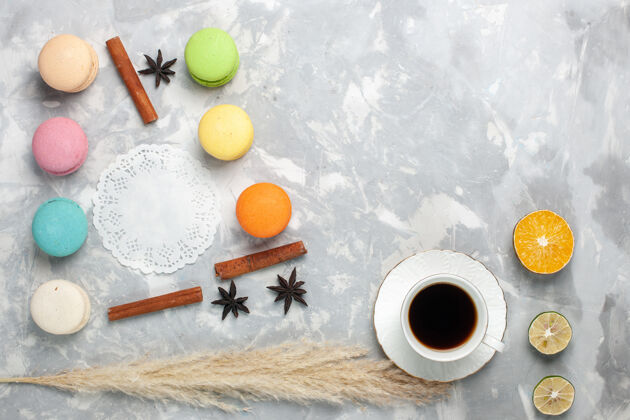 茶顶视图法国马卡龙与茶在浅白色的桌子上咖啡杯子杏仁饼