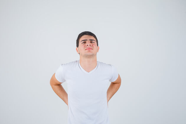 年轻年轻男性患有腰痛 穿着t恤衫 看上去不舒服 正面照压力痛苦头部