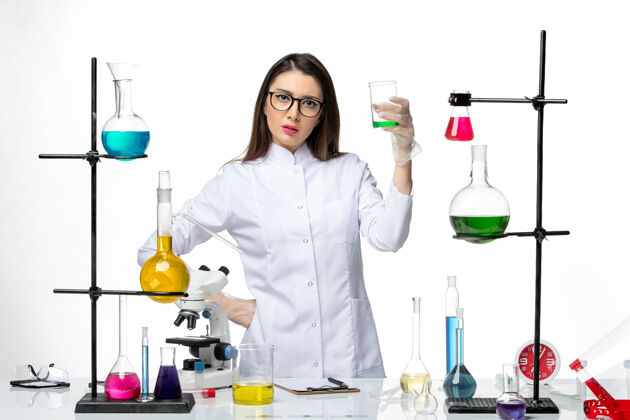 灭菌正面图：穿着无菌医疗服的女化学家拿着白色背景上有溶液的烧瓶实验室病毒共价-大流行科学容器科学医学